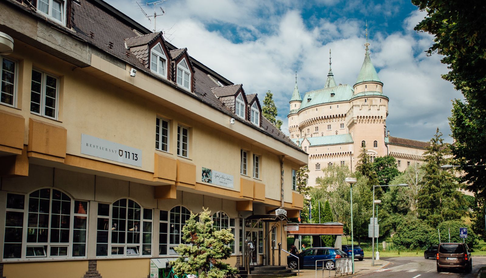 Hotel pod Zámkom v Bojniciach s Bojnickým zámkom v pozadí